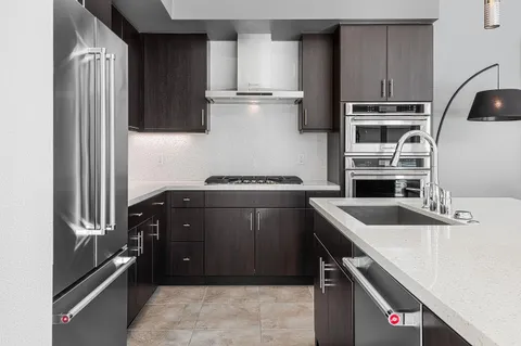 a kitchen with kitchen island a counter top space cabinets and stainless steel appliances