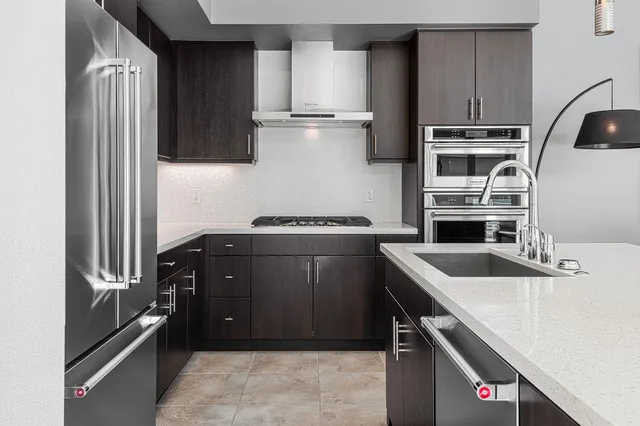 a kitchen with kitchen island a counter top space cabinets and stainless steel appliances