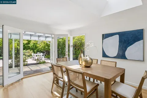 a kitchen with white cabinets and a large window