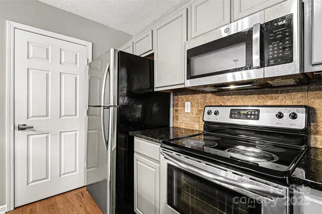 a kitchen with stainless steel appliances and white cabinets