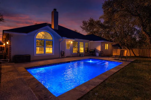 a view of swimming pool with a lounge chairs in patio
