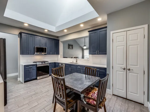 a kitchen with a table chairs microwave and refrigerator