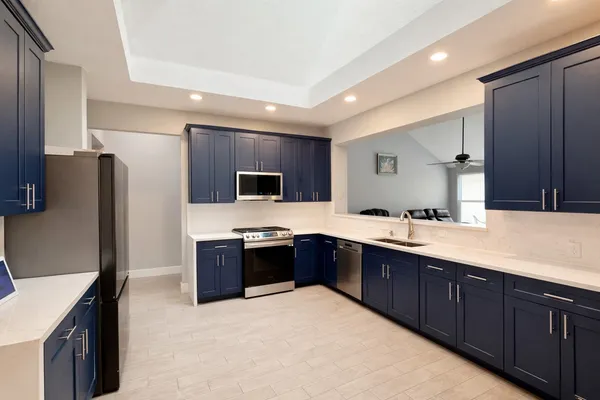 a kitchen with stainless steel appliances granite countertop a refrigerator stove a sink dishwasher and wooden cabinets with wooden floor