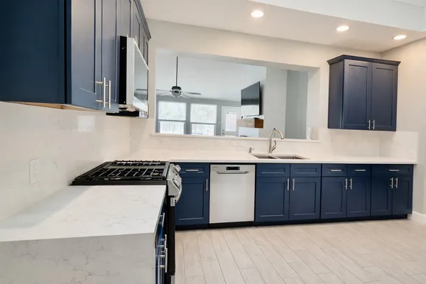 a kitchen with stainless steel appliances a refrigerator and wooden floor