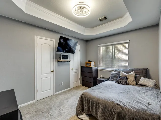 a bedroom with a bed and a refrigerator