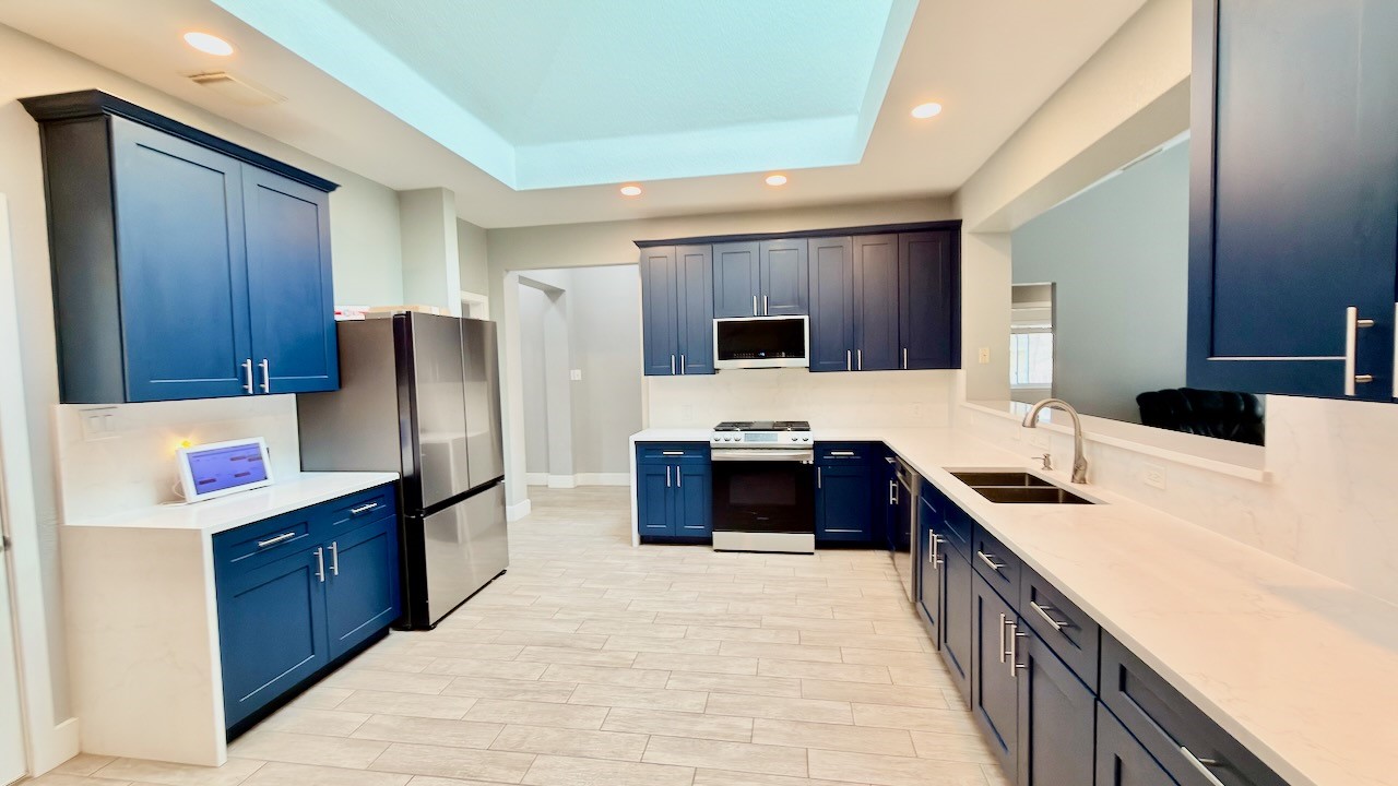 1902 Overland Drive Leander, TX 78641 - Photo 2 of 29 Remodeled eat-in kitchen updated cabinets, solid quartz counters and solid surface quartz backsplash and Velux skylight
