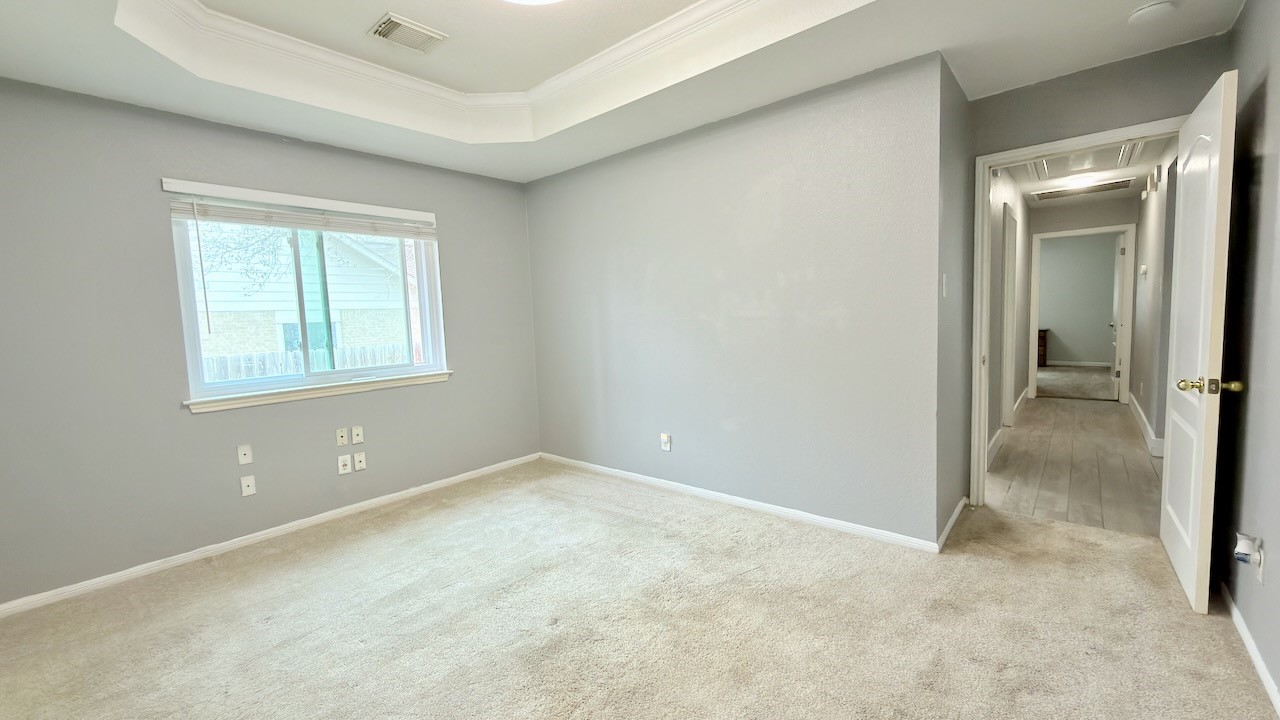 1902 Overland Drive Leander, TX 78641 - Photo 23 of 29 This generously sized secondary bedroom (1st of 3 secondary bedrooms) offers flexibility and comfort, featuring an elegant tray ceiling that adds visual interest and a sense of height. Dual closets provide excellent storage and organization, making the space easy to live in whether it’s used as a guest room, home office, or personal retreat. The room’s layout allows for larger furniture while still feeling open and inviting, creating a space that adapts effortlessly to a variety of needs.
