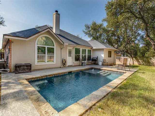 a view of a house with swimming pool and sitting area