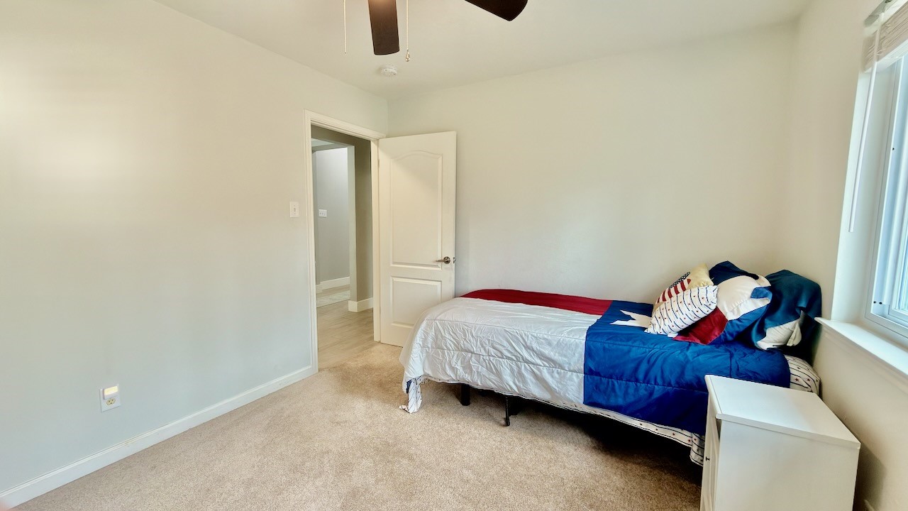 1902 Overland Drive Leander, TX 78641 - Photo 25 of 29 Secondary bedroom (2nd of 3 secondary bedrooms) filled with natural light, thanks to generous windows that keep the space bright and inviting throughout the day. A spacious walk-in closet offers excellent storage and flexibility, making this room ideal for guests or a personal retreat that adapts easily to your needs.