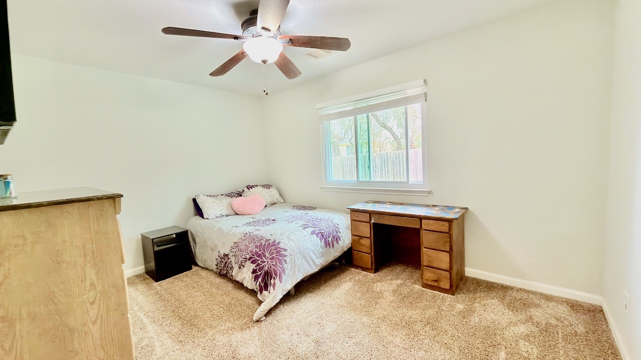 1902 Overland Drive Leander, TX 78641 - Photo 26 of 29 Spacious secondary bedroom (3rd of 3 secondary bedrooms) filled with natural light, featuring a walk-in closet and a peaceful location at the back of the home. Large windows overlook the backyard and pool, creating a bright, comfortable space that works beautifully as a guest room or personal retreat.