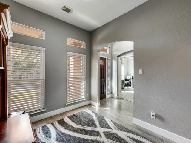 a view of a hallway with windows and chandelier