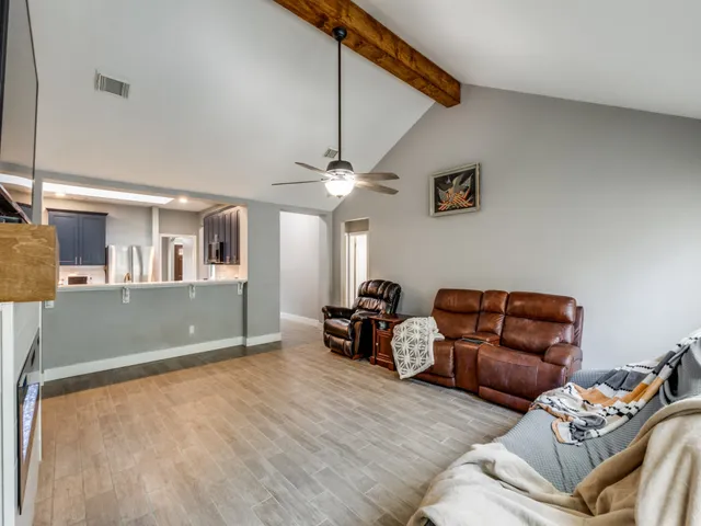 a living room with furniture and a ceiling fan
