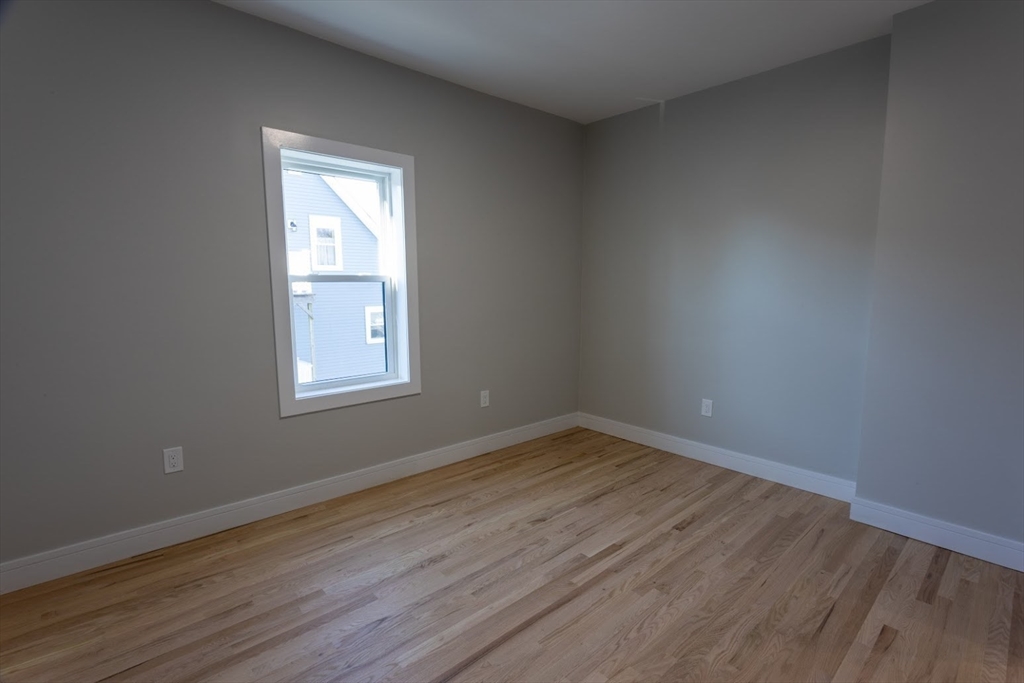 75 Sycamore Street Everett, MA 02149 - Photo 12 of 25 an empty room with wooden floor and windows
