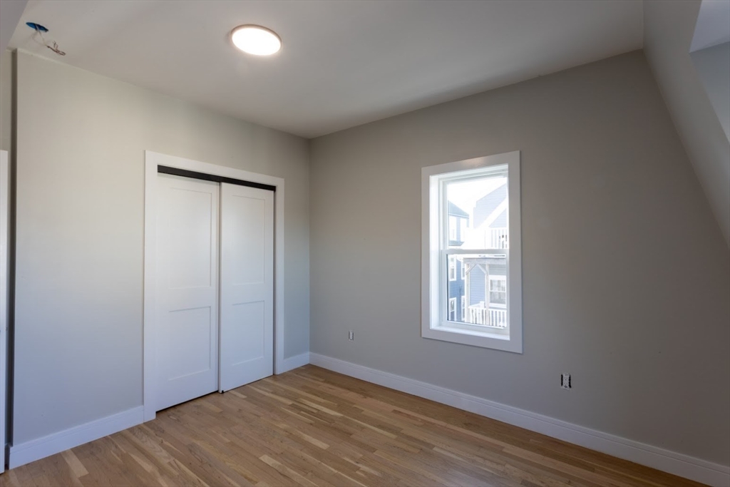 75 Sycamore Street Everett, MA 02149 - Photo 15 of 25 an empty room with wooden floor and windows