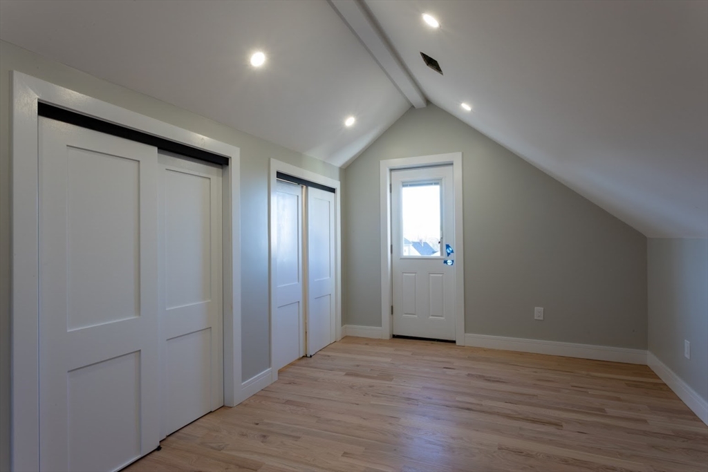 75 Sycamore Street Everett, MA 02149 - Photo 17 of 25 an empty room with wooden floor and windows