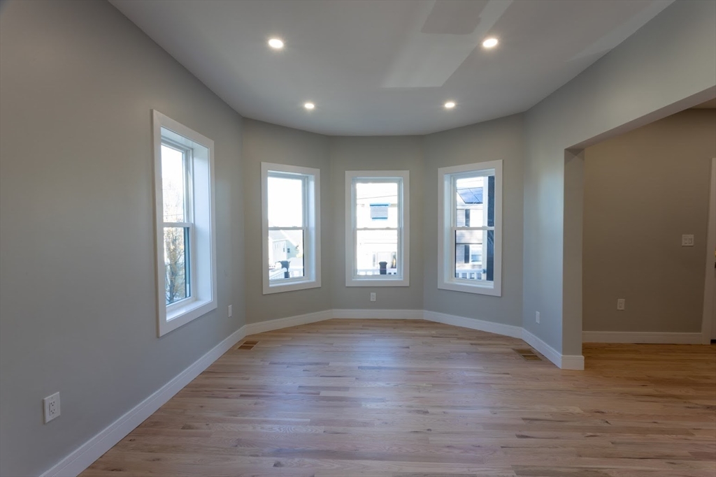 75 Sycamore Street Everett, MA 02149 - Photo 4 of 25 a view of empty room with wooden floor and fan