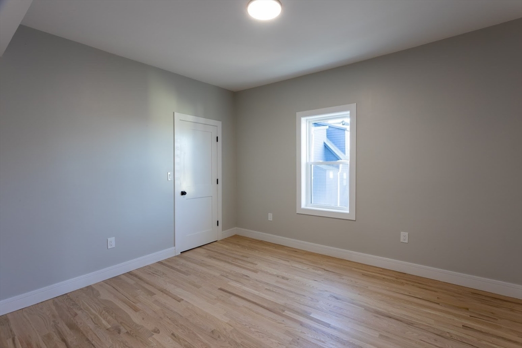 75 Sycamore Street Everett, MA 02149 - Photo 10 of 25 an empty room with wooden floor and windows
