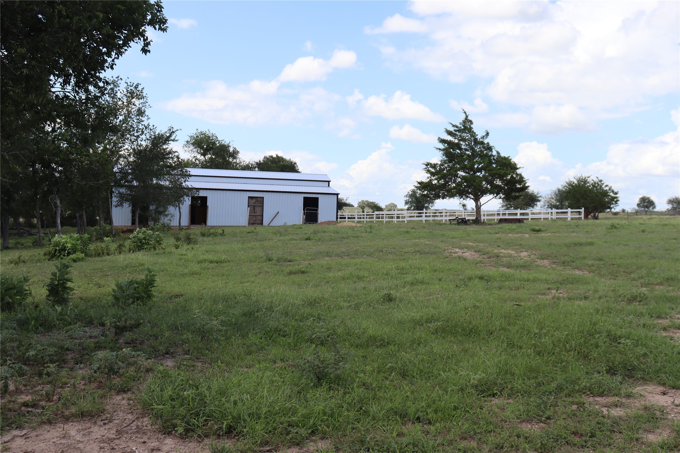 1220 Brushy Branch Road Lockhart, TX 78644 - Photo 11 of 14 A spacious barn nestled in a verdant field, offering ample utility and pastoral charm.