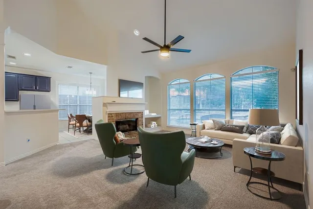a living room with furniture a fireplace and a large window