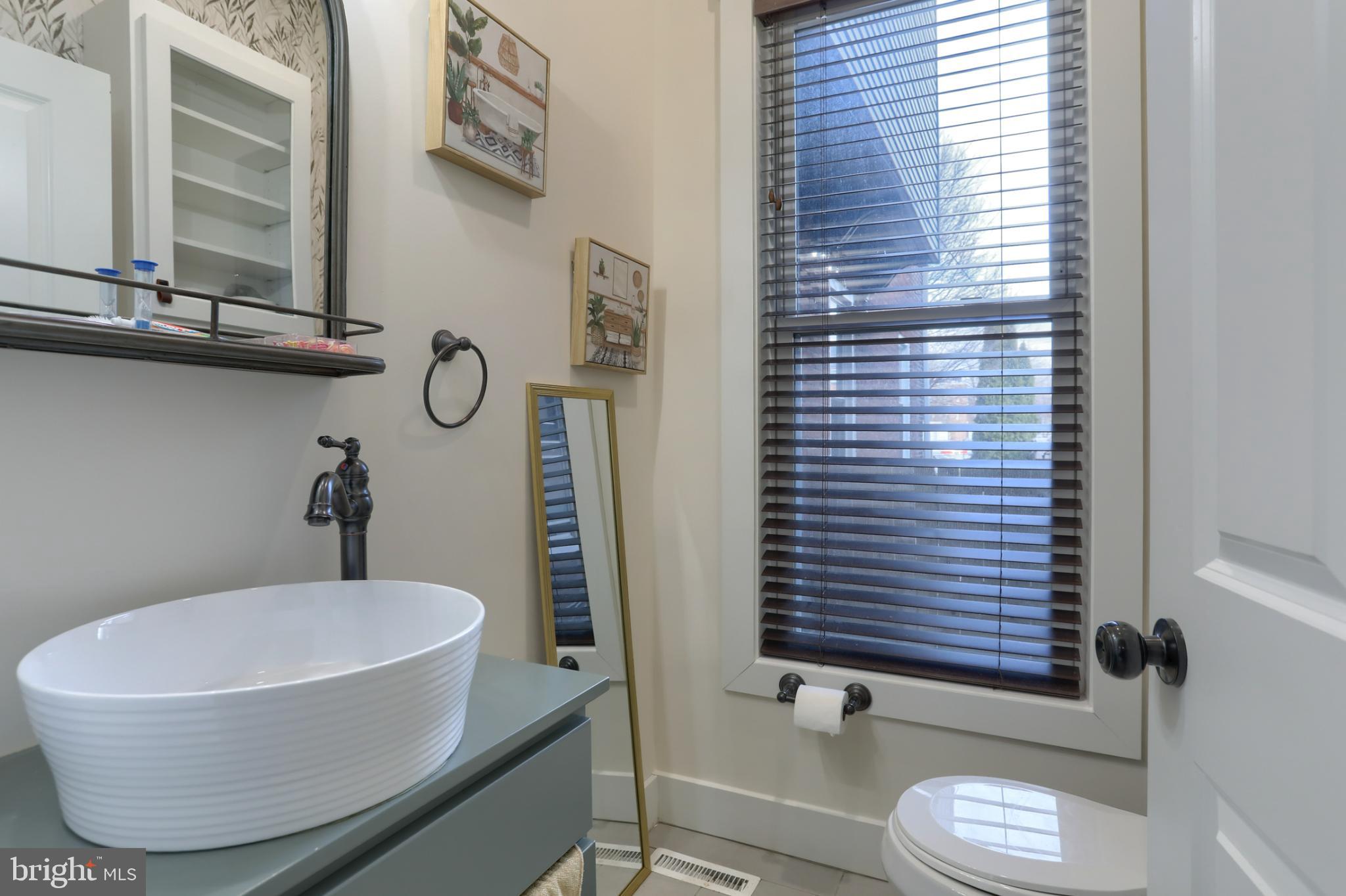 140 South 8th Street Lebanon, PA 17042 - Photo 10 of 34 a bathroom with a toilet a sink and mirror