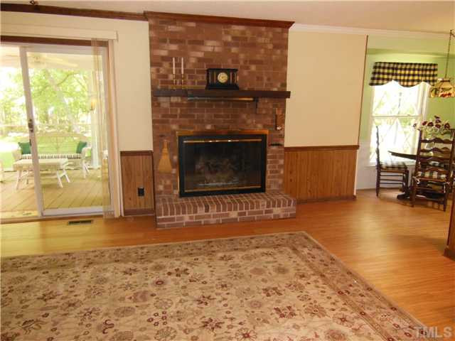 1115 Briardale Road Durham, NC 27712 - Photo 18 of 25 a living room with a fireplace windows and a table
