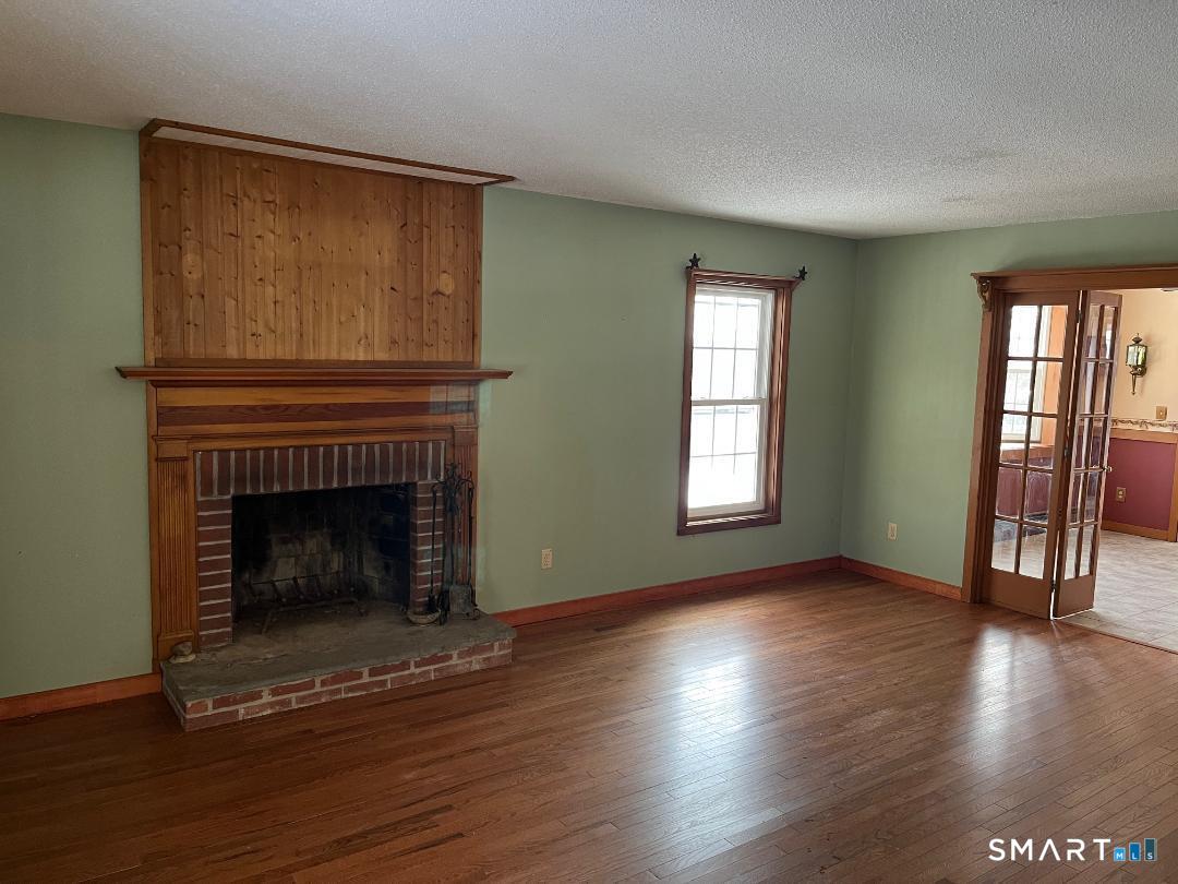 37 Potter School Road Willington, CT 06279 - Photo 2 of 31 an empty room with wooden floor fireplace and windows