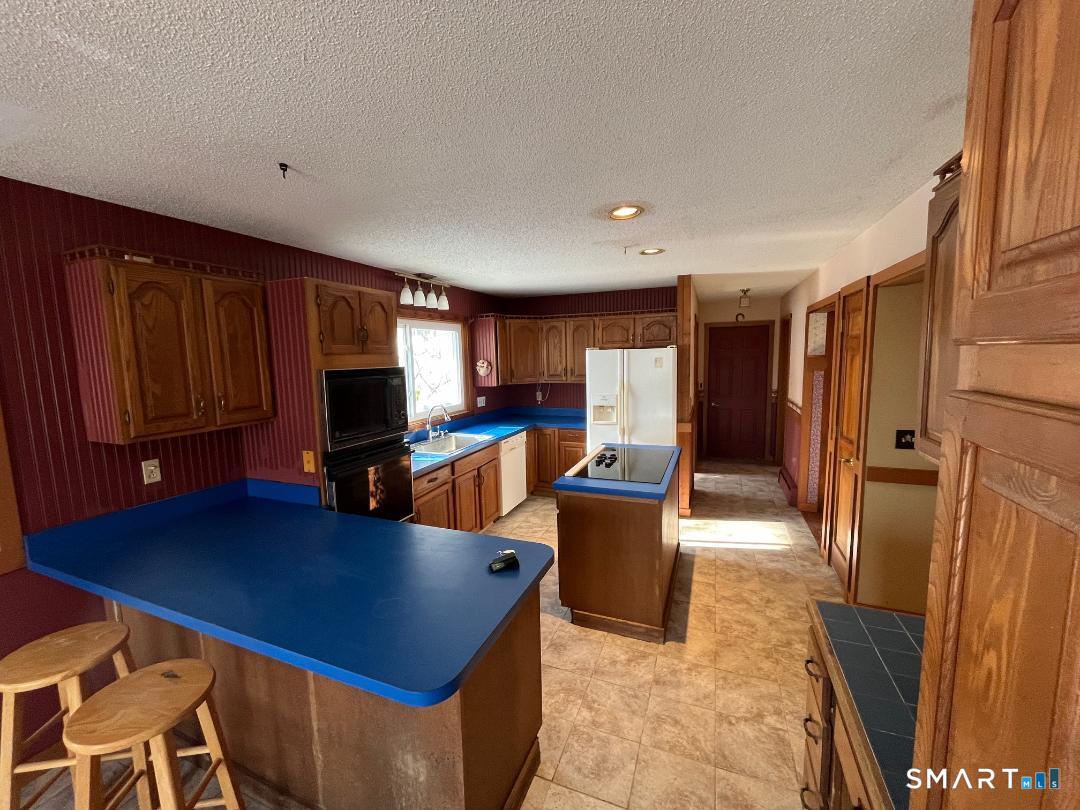 37 Potter School Road Willington, CT 06279 - Photo 8 of 31 a living room with furniture a flat screen tv and kitchen view