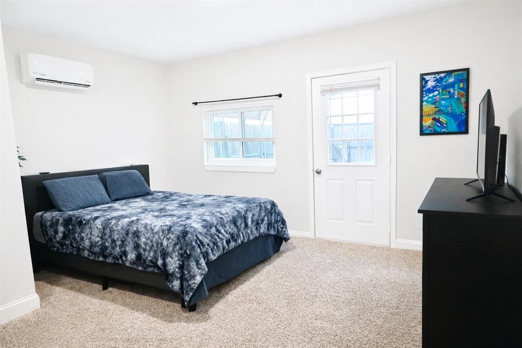 2223 Ridgedale Drive Carrollton, TX 75006 - Photo 16 of 27 a bedroom with a bed flat screen tv and window