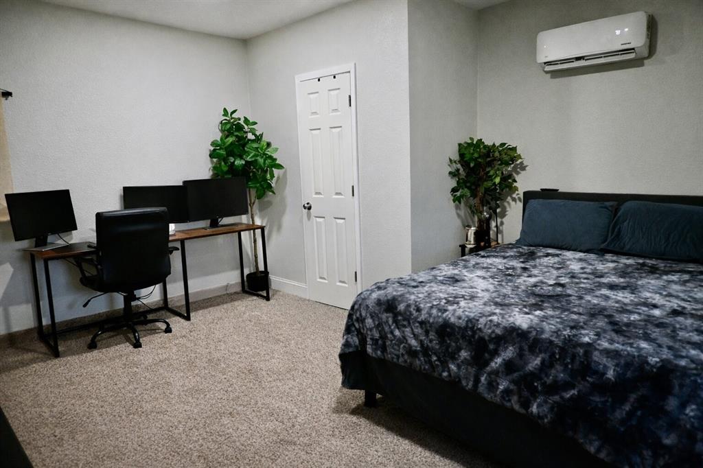 2223 Ridgedale Drive Carrollton, TX 75006 - Photo 17 of 27 a bedroom with a bed table chair and a potted plant