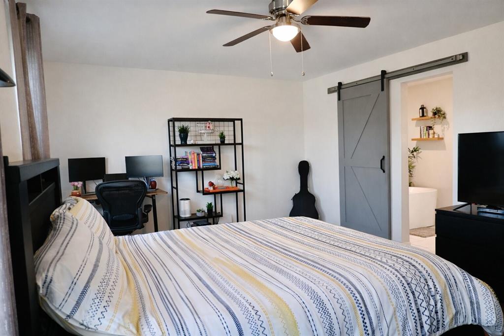 2223 Ridgedale Drive Carrollton, TX 75006 - Photo 9 of 27 a bedroom with bed and a flat tv screen