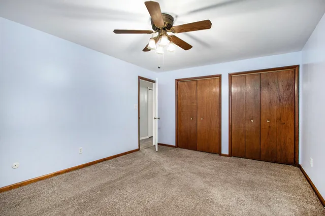 an empty room with closet and fan