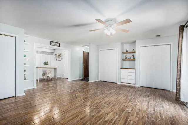 a view of empty room with wooden floor