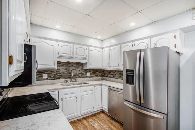 a kitchen with a refrigerator sink and cabinets