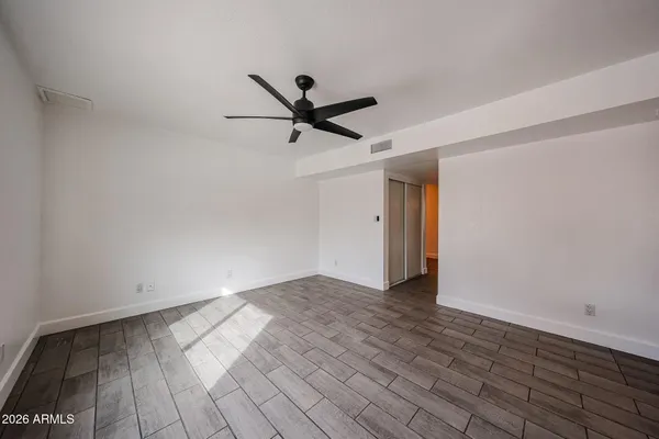 a view of empty room with wooden floor