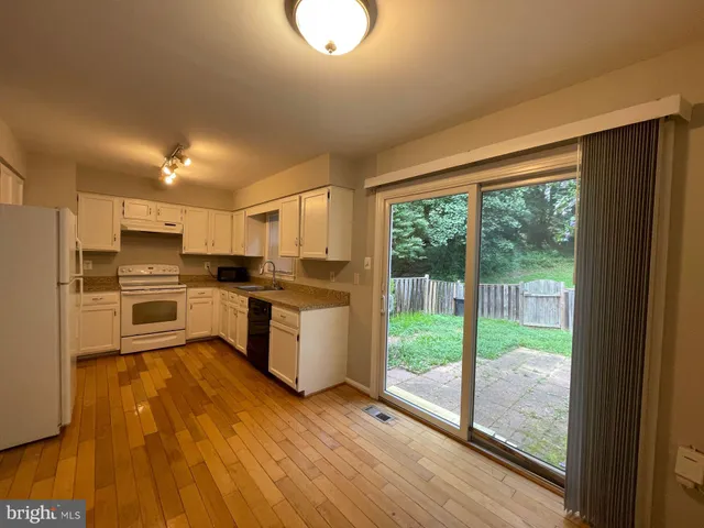 a kitchen with a refrigerator a stove top oven and a large window