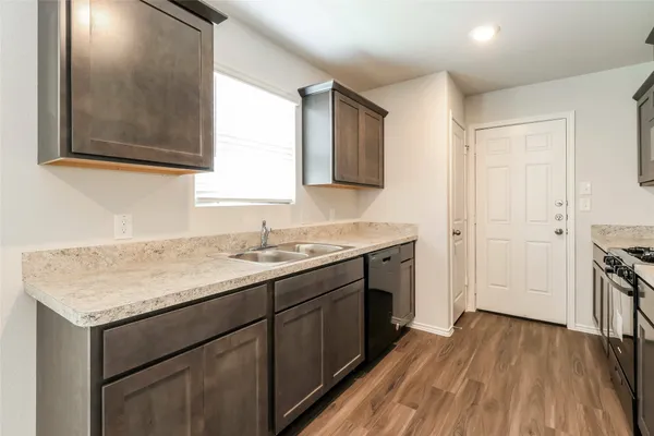 a kitchen with a sink stove and cabinets