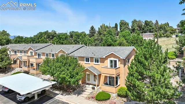 an aerial view of a house with yard and mountain view in back