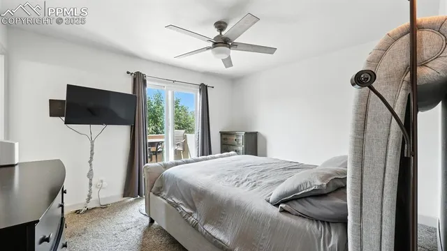 a bedroom with a bed tv and a window