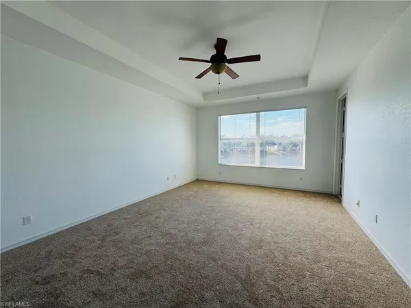 an empty room with windows and ceiling fan view