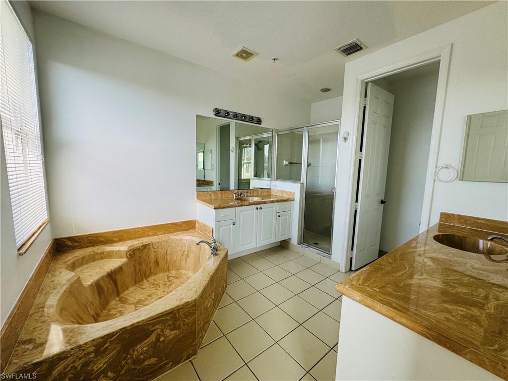 1400 Mariposa Circle, Unit 103 Naples, FL 34105 - Photo 12 of 22 a bathroom with a tub sink and mirror