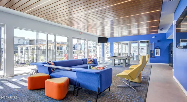 a living room with furniture and floor to ceiling windows