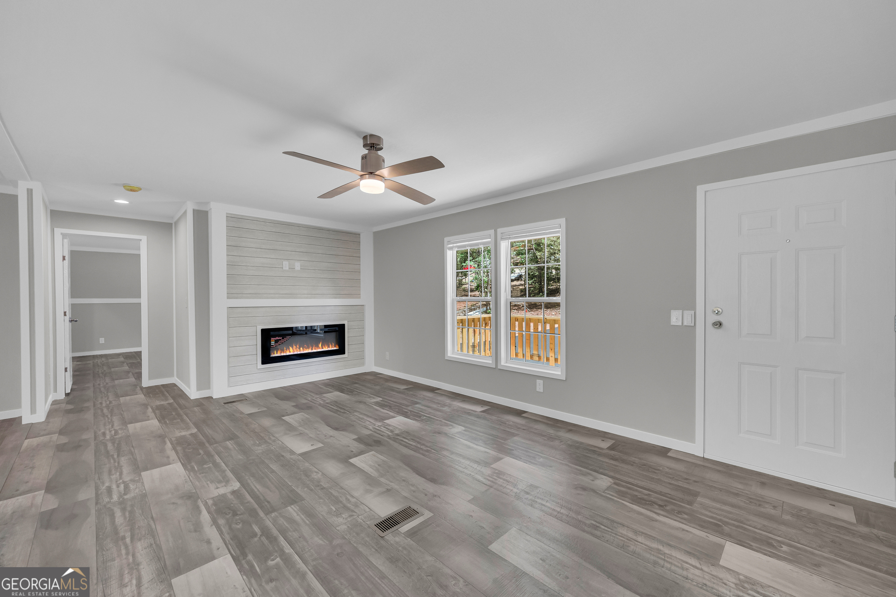 3442 Highway 29 Street South Colbert, GA 30628 - Photo 14 of 39 a view of a livingroom with a fireplace a ceiling fan and windows