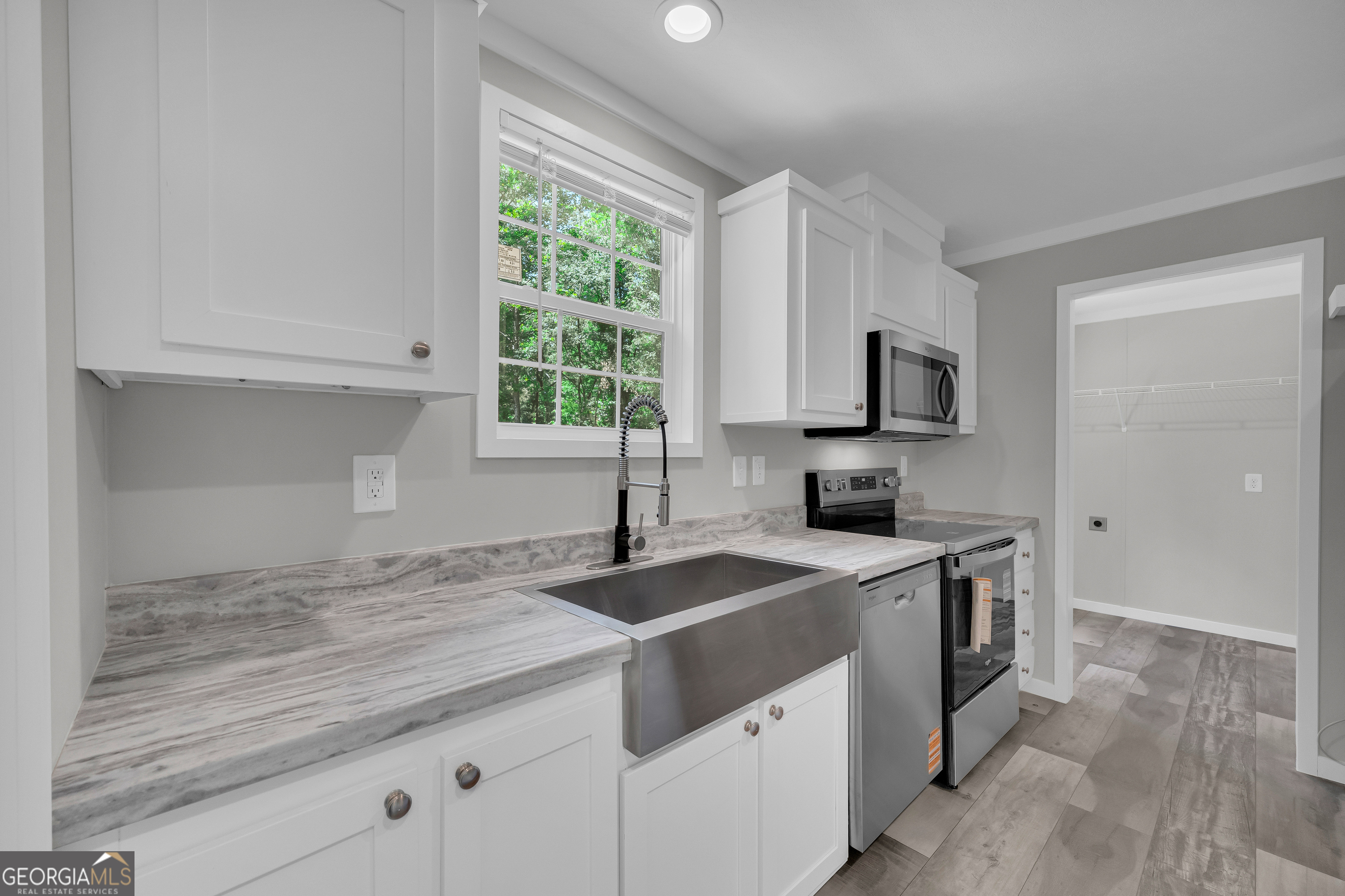 3442 Highway 29 Street South Colbert, GA 30628 - Photo 21 of 39 a kitchen with granite countertop a sink stainless steel appliances and white cabinets