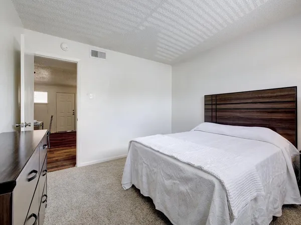 a bedroom with a bed and wooden floor
