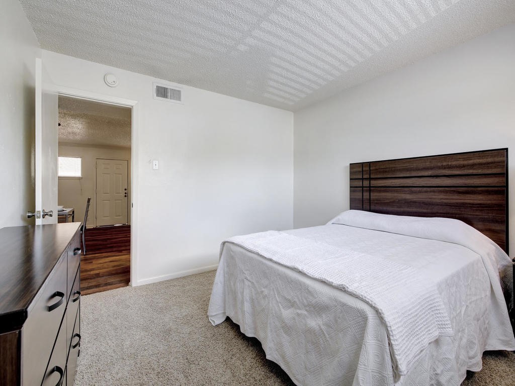 4539 Guadalupe Street, Unit A207 Austin, TX 78751 - Photo 23 of 31 a bedroom with a bed and wooden floor