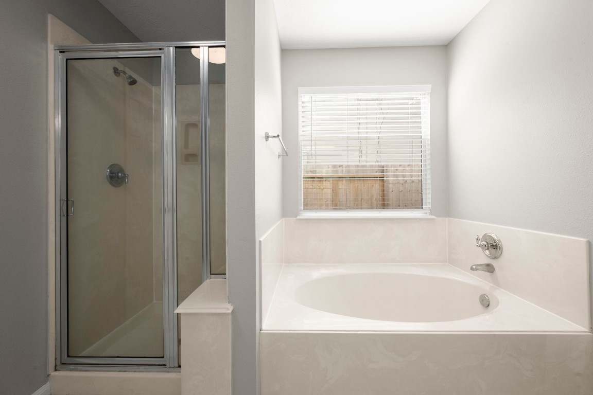 7 Delta Mill Court Conroe, TX 77385 - Photo 14 of 25 a white bath tub sitting next to a window