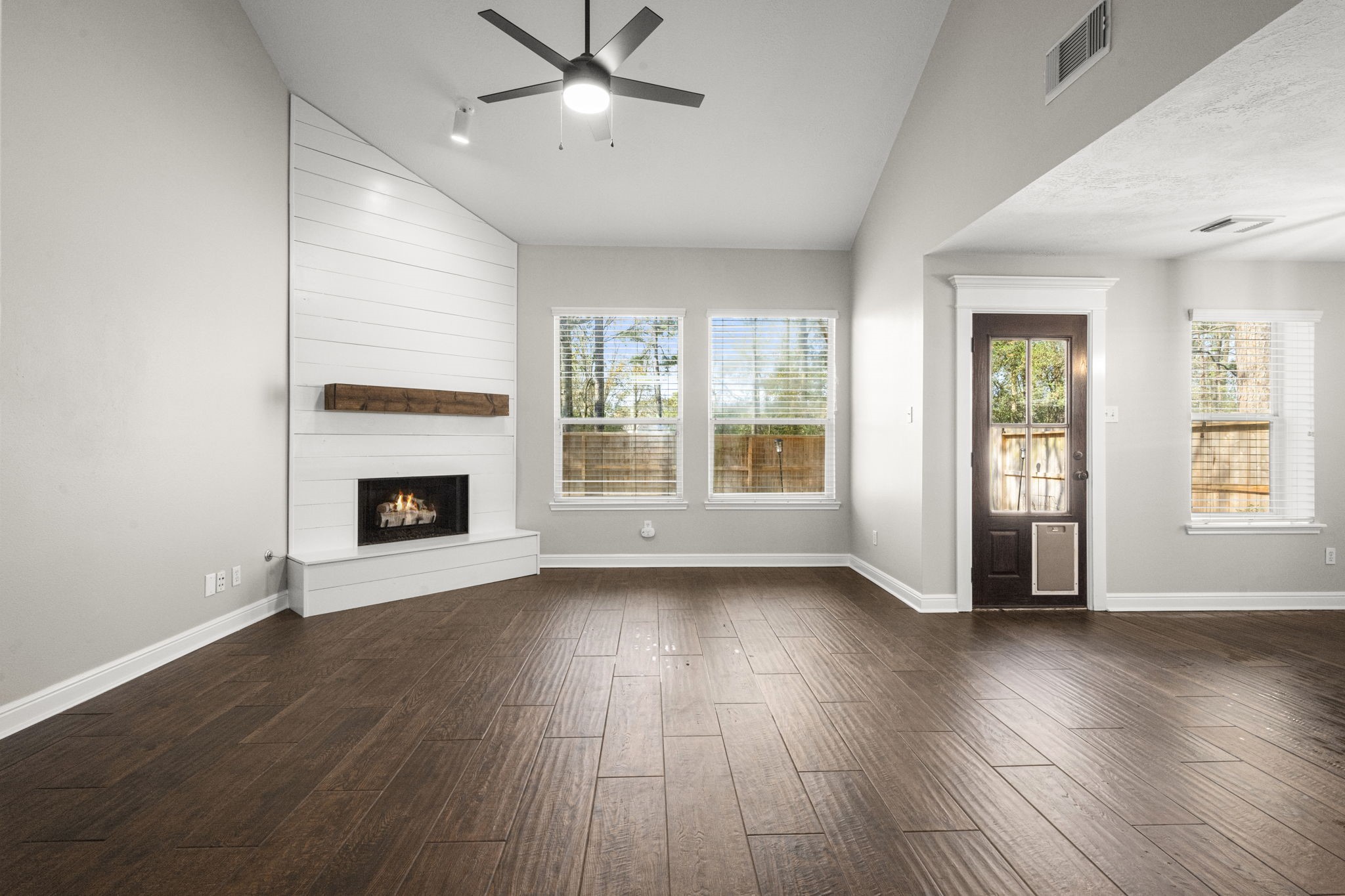 7 Delta Mill Court Conroe, TX 77385 - Photo 4 of 25 an empty room with wooden floor fireplace and windows