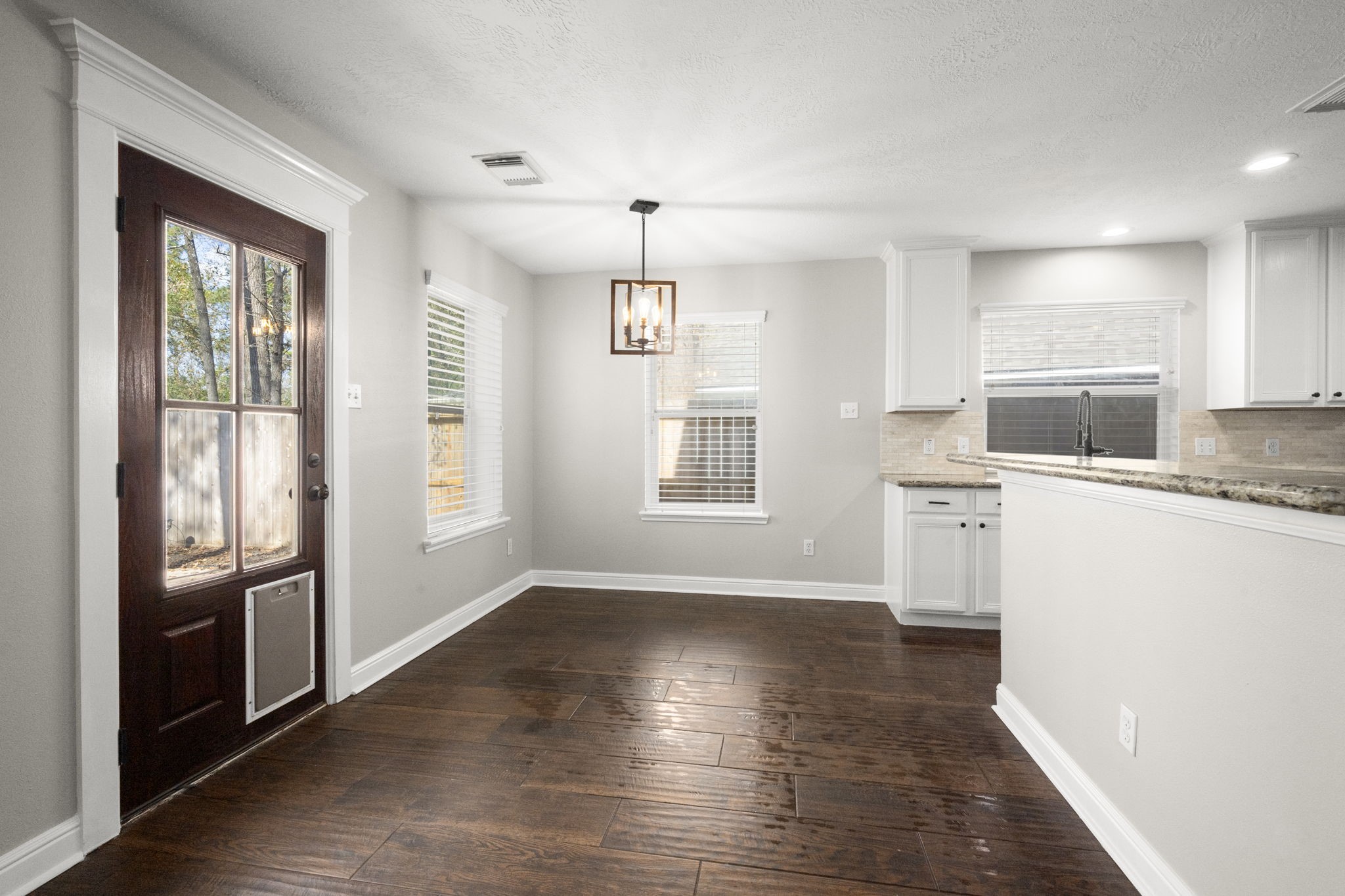 7 Delta Mill Court Conroe, TX 77385 - Photo 7 of 25 a kitchen with granite countertop a stove a sink and a refrigerator