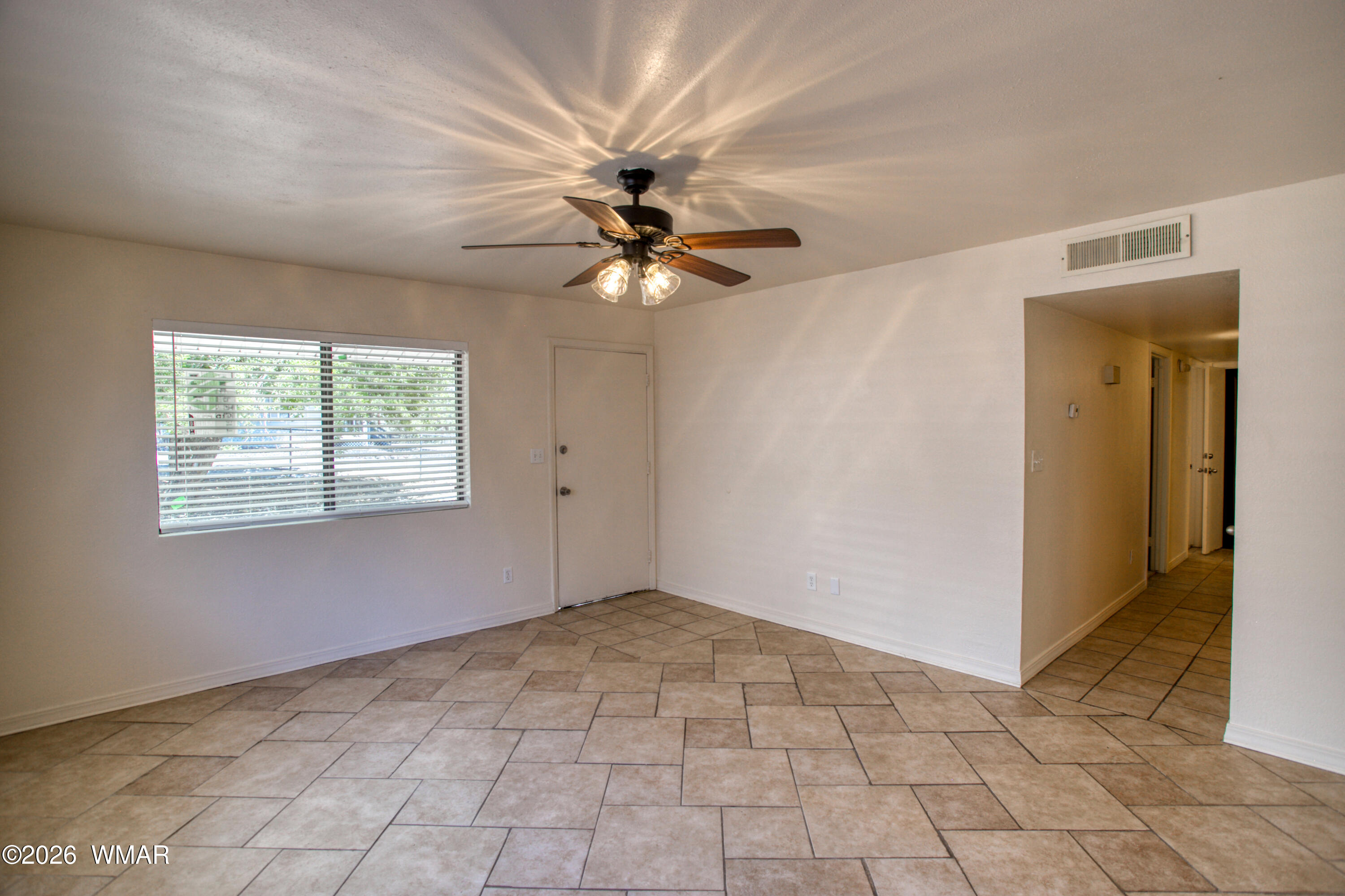 411 West Stratton Show Low, AZ 85901 - Photo 3 of 47 a view of an empty room with a ceiling fan and a window