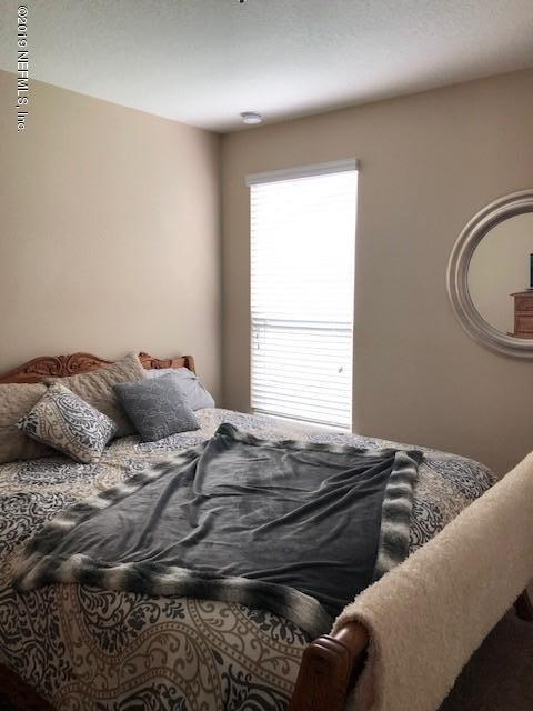 188 Antilles Road St. Augustine, FL 32092 - Photo 20 of 43 a bed sitting in a bedroom next to a window